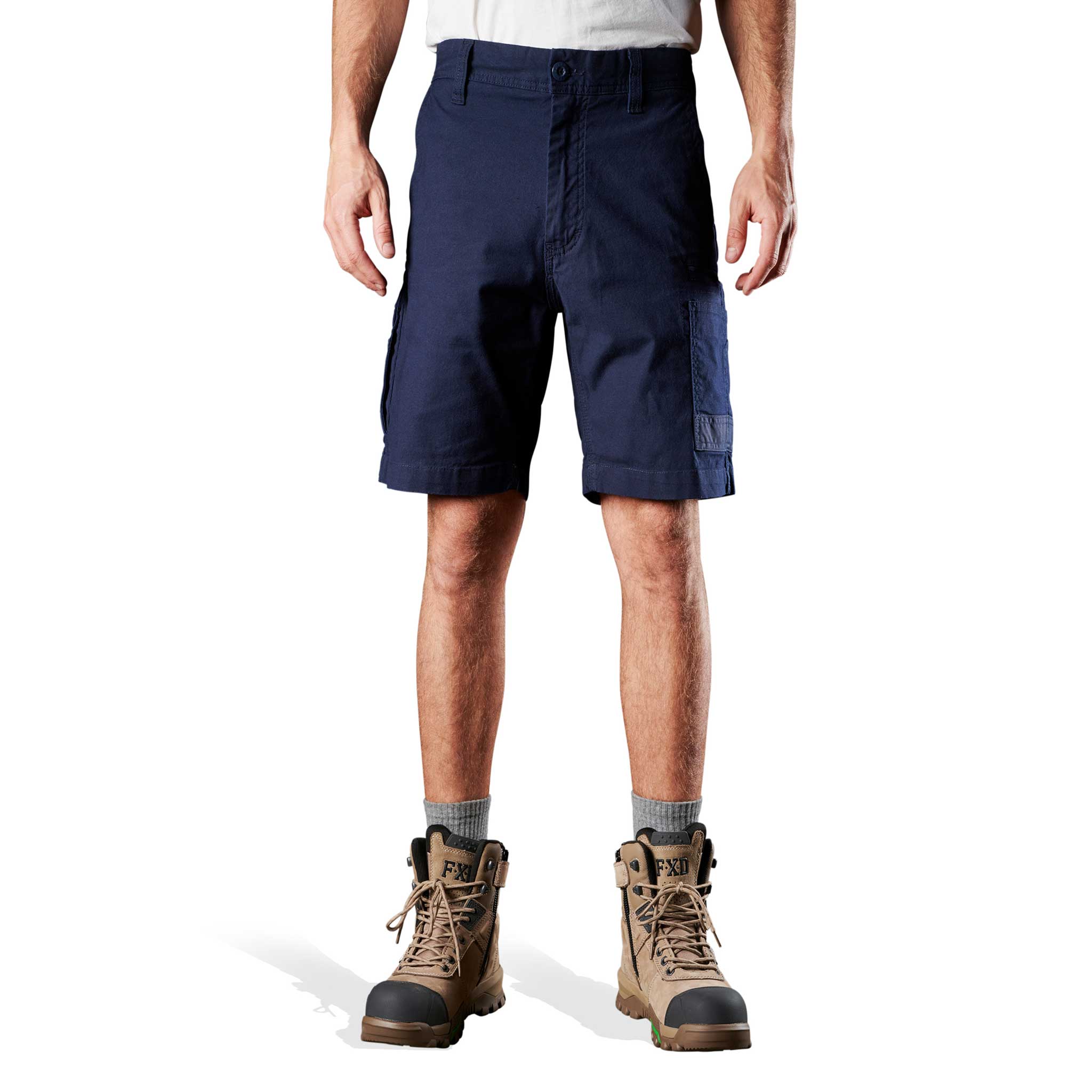 A person standing and wearing navy blue FXD stretch canvas work shorts 