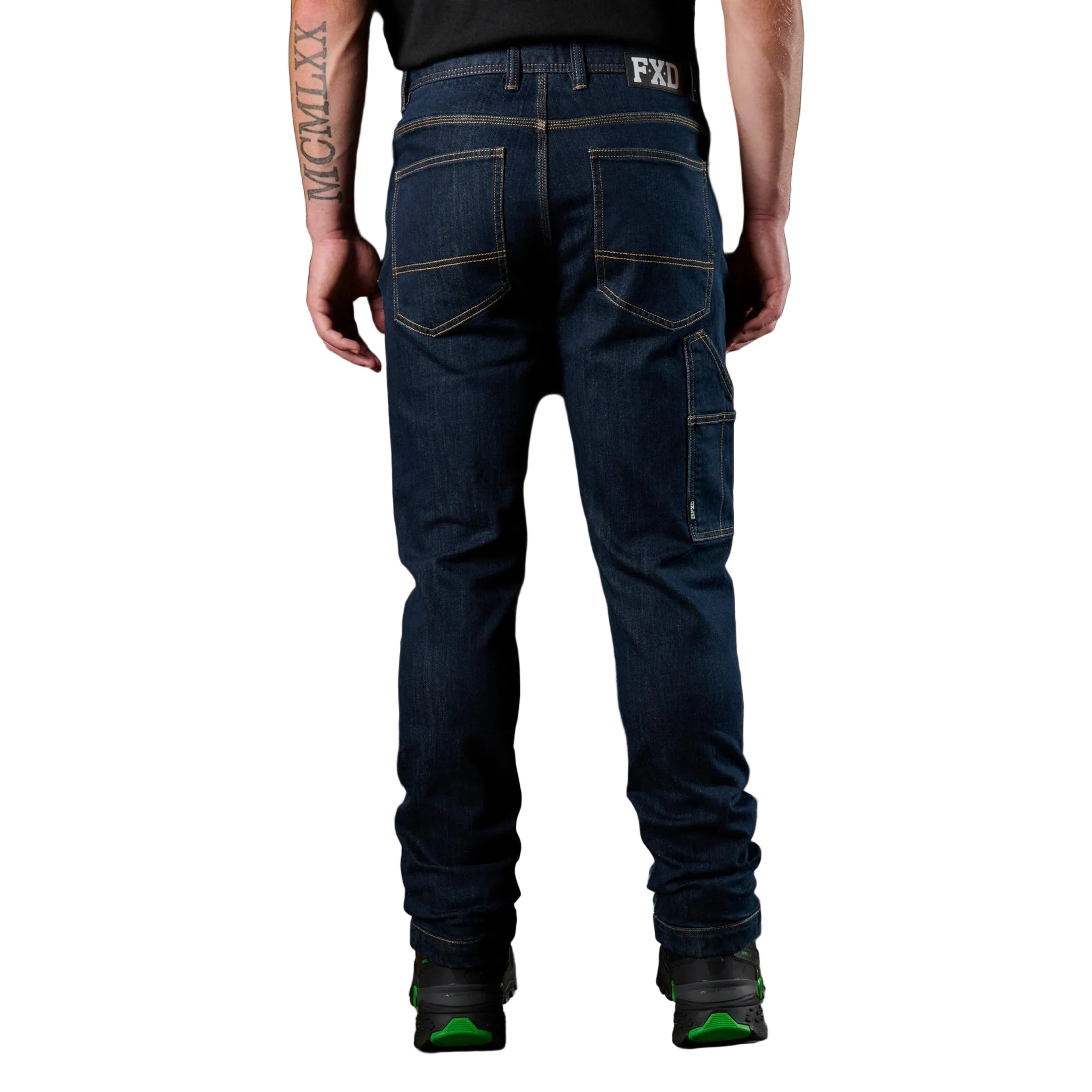 Person wearing dark blue jeans with FXD branding on a black background