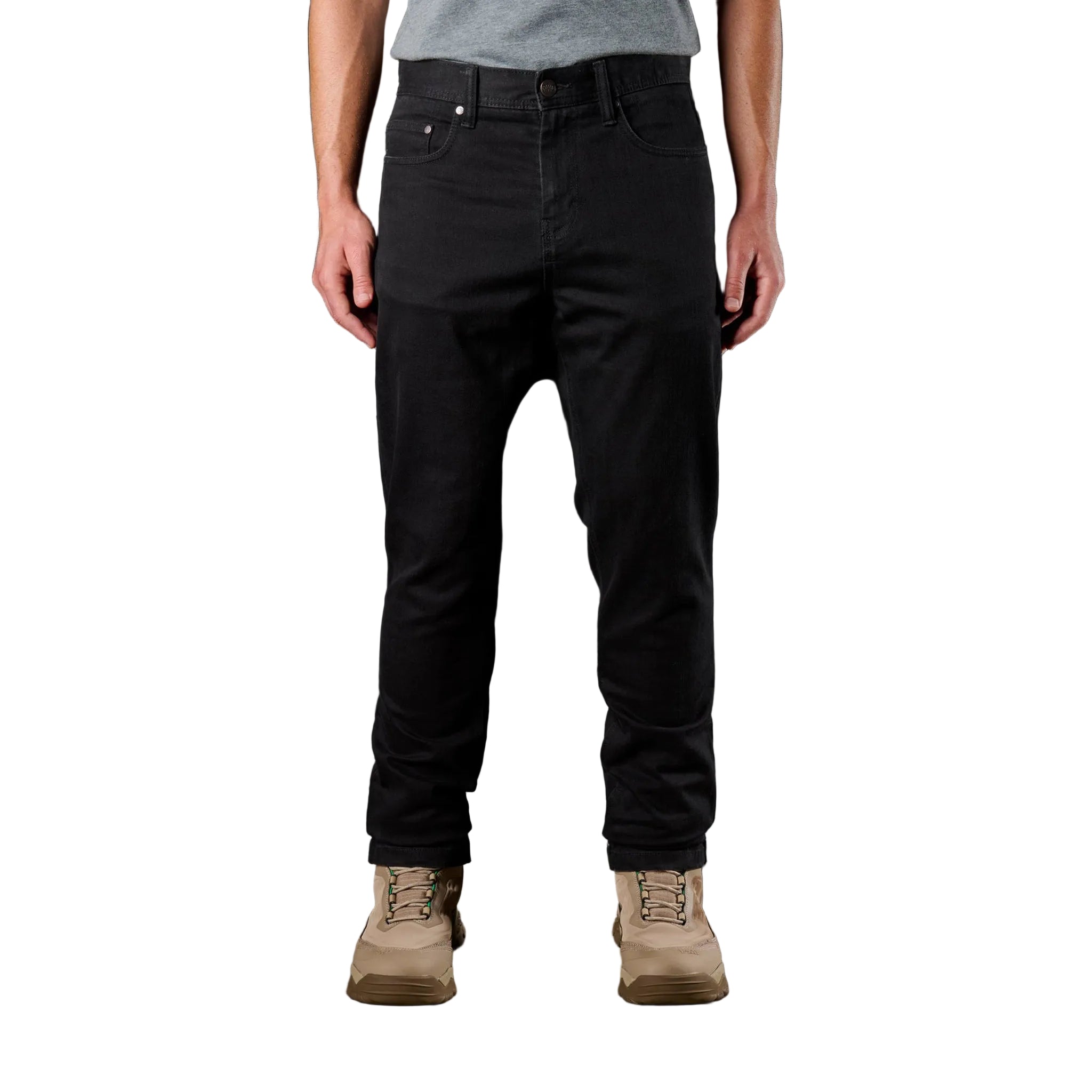 Person wearing black pants and tan boots on a dark background